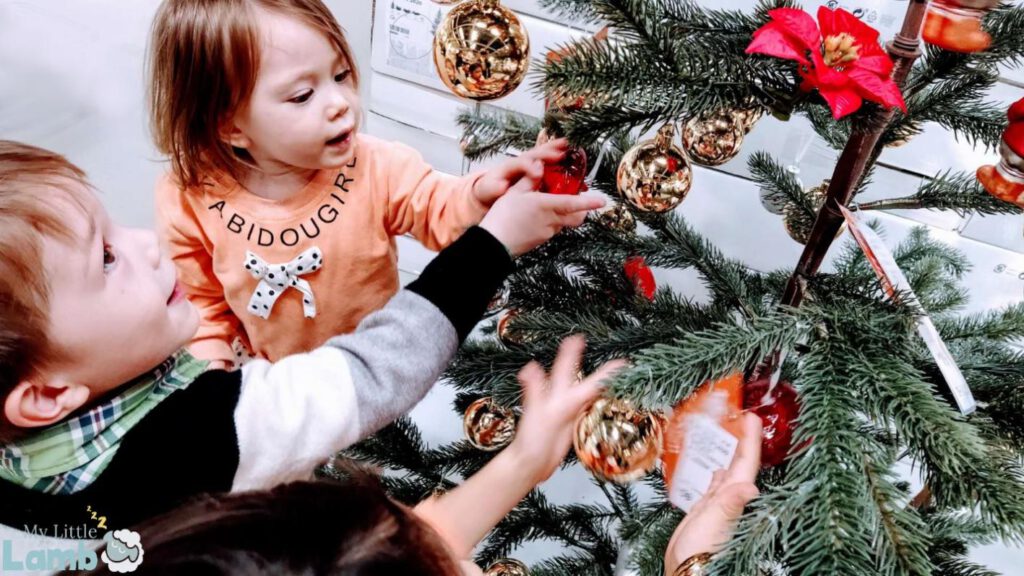 Little girl and little boy around the Christmas tree