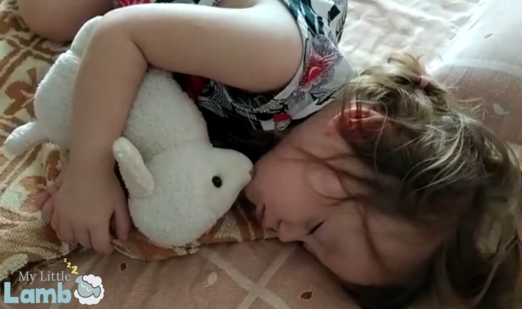 Little girl sleeping with My Little Lamb, a soft plushy toy with integrated audio player