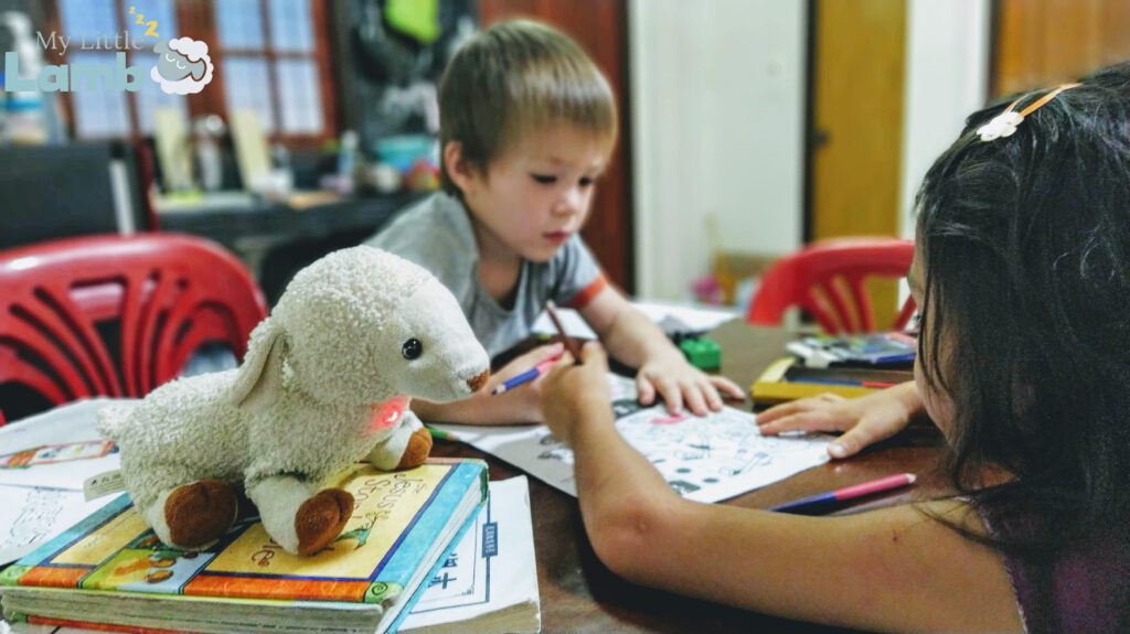 A boy and a girl studying with My Little Lamb,  a soft plushy toy with integrated audio player